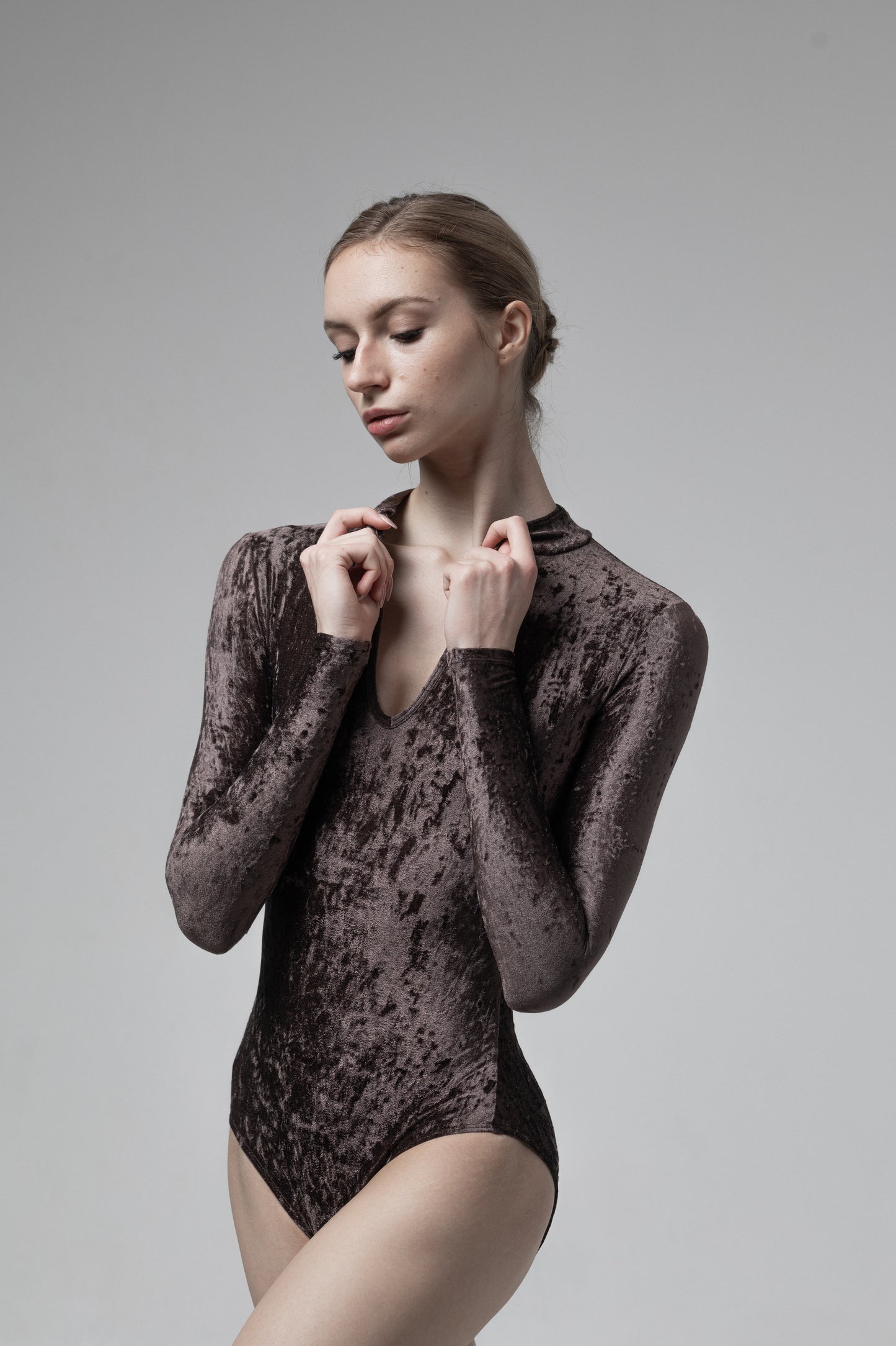Dancelab Dancer wearing a dark brown velvet bodysuit against a gray background