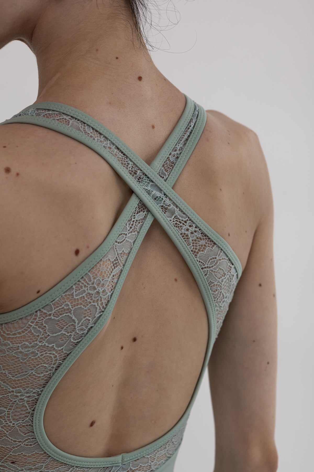 Light green ballet leotard worn by a dancer on a plain background