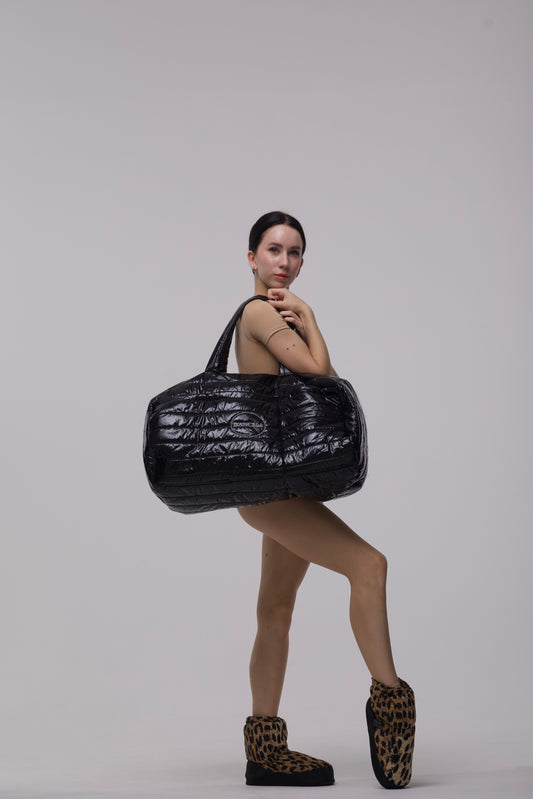 Ballerina holding a large black textured bag
