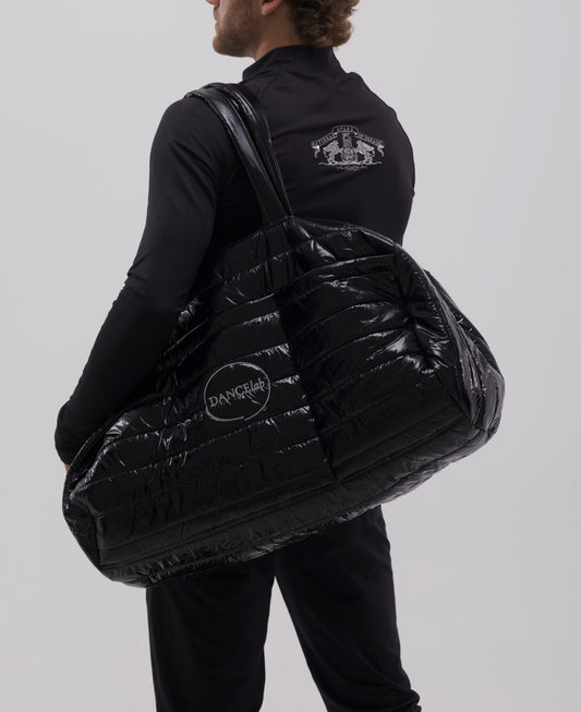 Dancer holding a large black textured bag