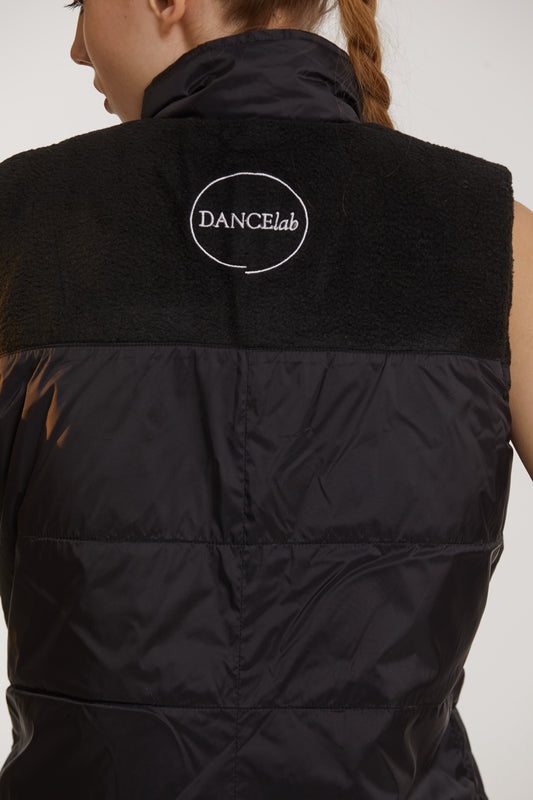 Black puffer vest with 'DANCElab' logo on a plain background
