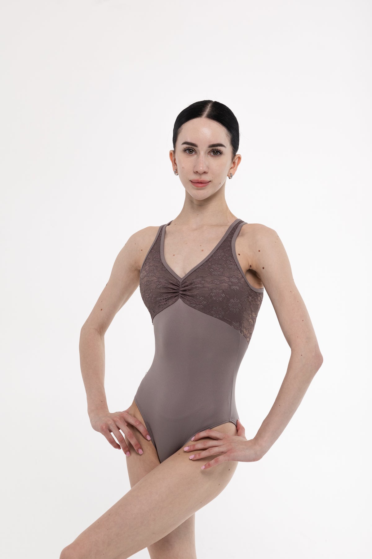 Woman wearing a brown ballet leotard on a white background