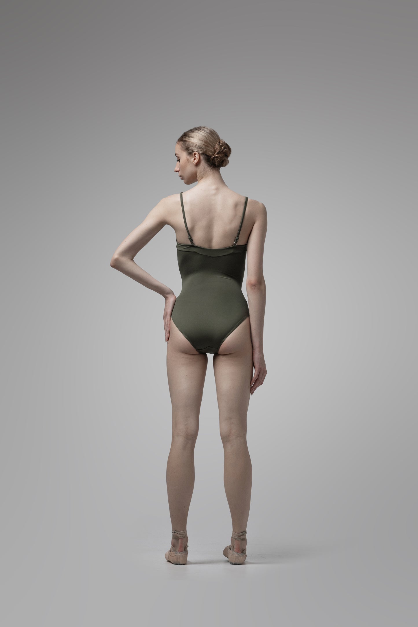 Person wearing a green swimsuit on a gray background