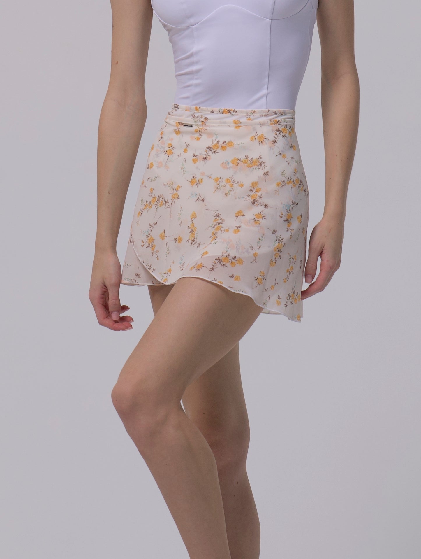 Girl wearing a white top and floral skirt 