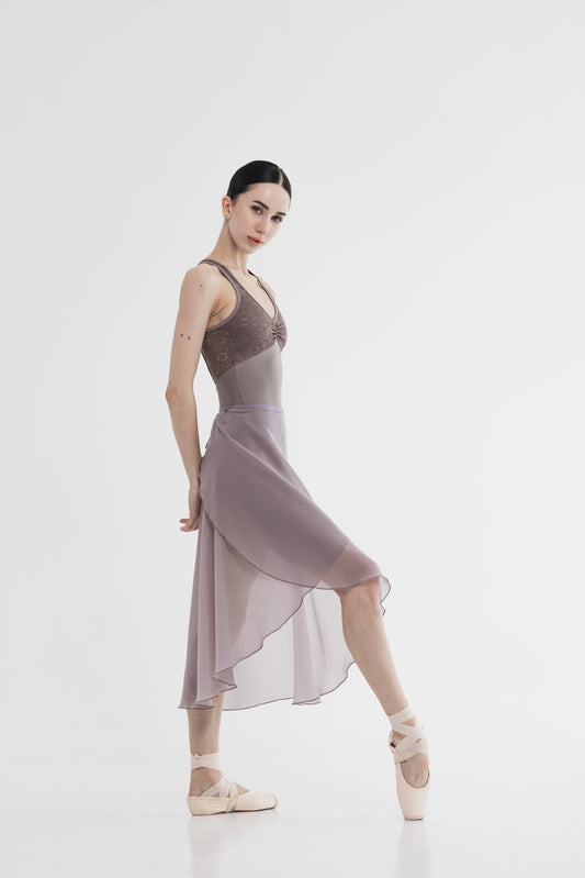 Dancer in a long skirt posing on a white background