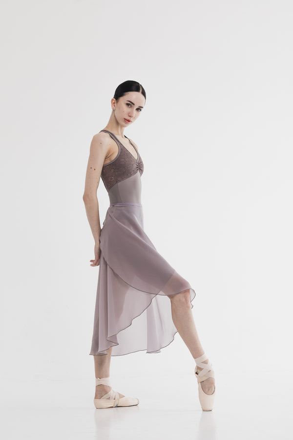 Dancer in a long skirt posing on a white background