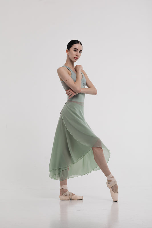 Girl in a pistachio skirt posing against a white background